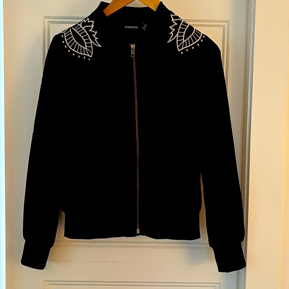 distinctive black zip-up jacket featuring a white design